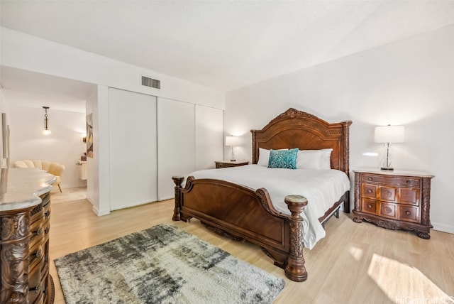 bedroom with light wood-type flooring and a closet