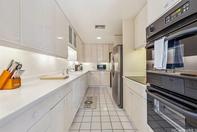 kitchen featuring light tile patterned floors, white cabinetry, sink, and appliances with stainless steel finishes