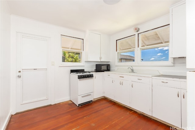 kitchen featuring white cabinetry, dark hardwood / wood-style floors, and white gas range oven