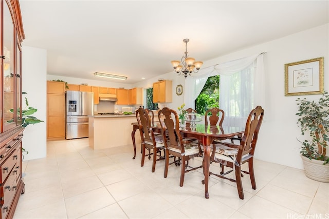 tiled dining room featuring a chandelier