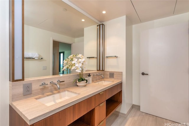 bathroom featuring hardwood / wood-style flooring, vanity, and backsplash