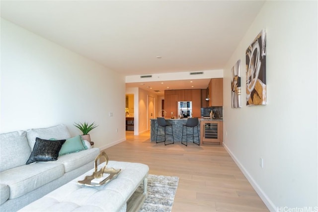 living room with beverage cooler and light wood-type flooring