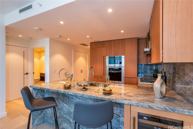 kitchen with sink, light wood-type flooring, stainless steel appliances, beverage cooler, and backsplash