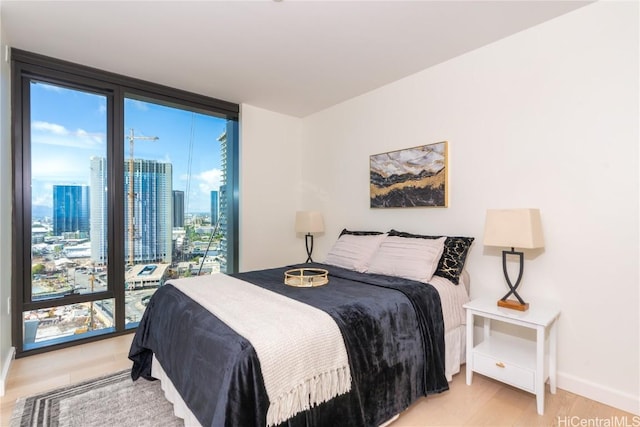 bedroom featuring floor to ceiling windows and hardwood / wood-style floors