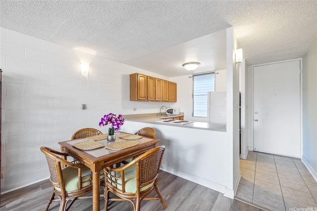 5122 Likini St Unit 302, Honolulu, HI 96818 - dining area with a textured ceiling and light wood finished floors
