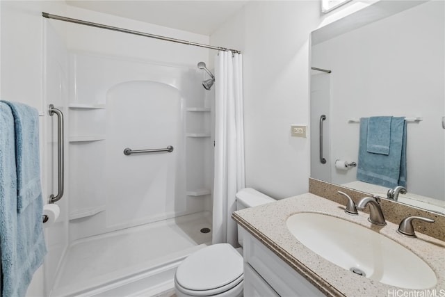 bathroom featuring toilet, vanity, and walk in shower