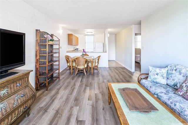 5122 Likini St Unit 302, Honolulu, HI 96818 - living area with wood finished floors, a textured ceiling, healthy amount of natural light, and baseboards