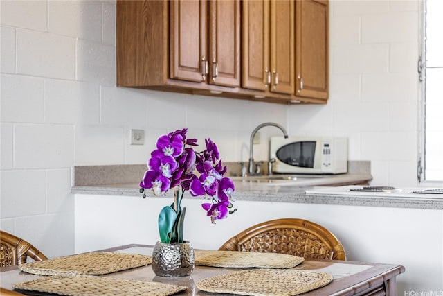 5122 Likini St Unit 302, Honolulu, HI 96818 - kitchen featuring light countertops, brown cabinets, white microwave, and decorative backsplash
