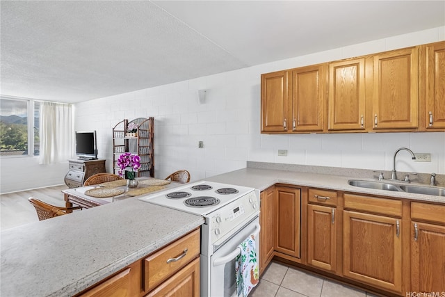 5122 Likini St Unit 302, Honolulu, HI 96818 - kitchen featuring electric range, a sink, light countertops, brown cabinets, and a textured ceiling