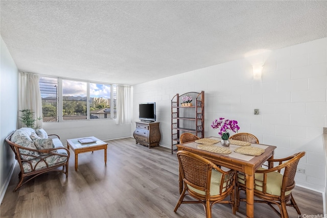 5122 Likini St Unit 302, Honolulu, HI 96818 - dining space featuring a textured ceiling, wood finished floors, and concrete block wall
