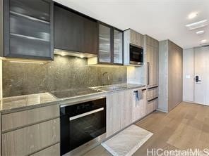 kitchen with decorative backsplash, sink, stainless steel appliances, and light hardwood / wood-style floors