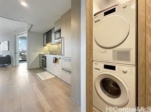 washroom featuring stacked washer / dryer and light wood-type flooring