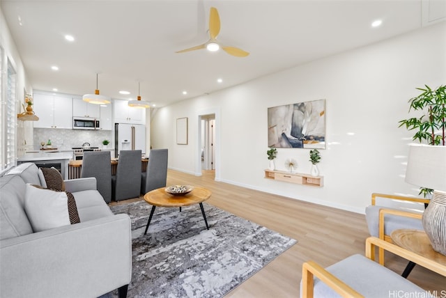 living room with ceiling fan and light hardwood / wood-style floors