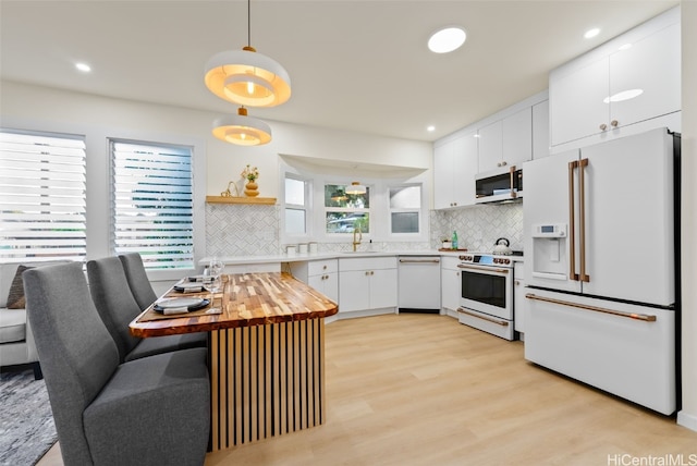 kitchen with white cabinetry, light hardwood / wood-style flooring, wooden counters, pendant lighting, and white appliances