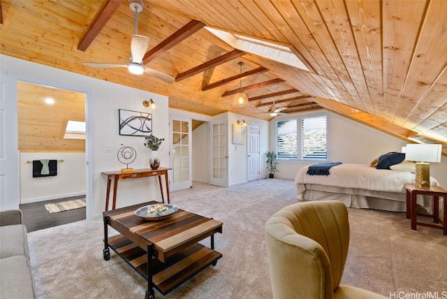 carpeted bedroom featuring lofted ceiling with skylight, ceiling fan, and wood ceiling