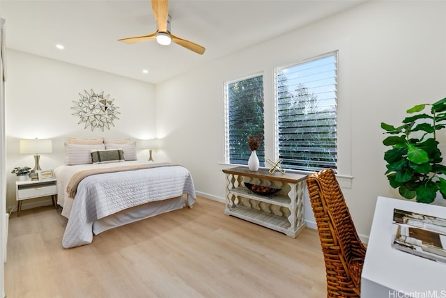 bedroom featuring light hardwood / wood-style floors, multiple windows, and ceiling fan