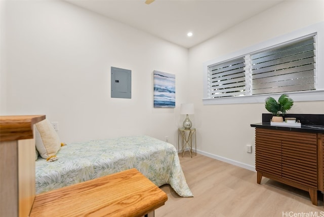 bedroom with electric panel and light hardwood / wood-style flooring