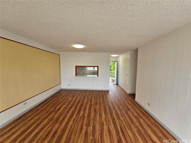 unfurnished room with dark hardwood / wood-style flooring and a textured ceiling