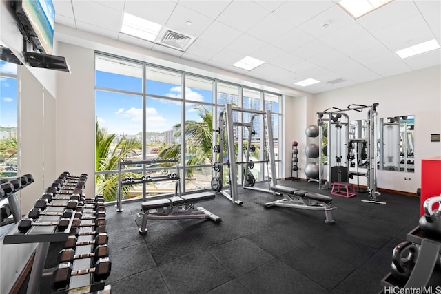 exercise room featuring a drop ceiling and a wealth of natural light