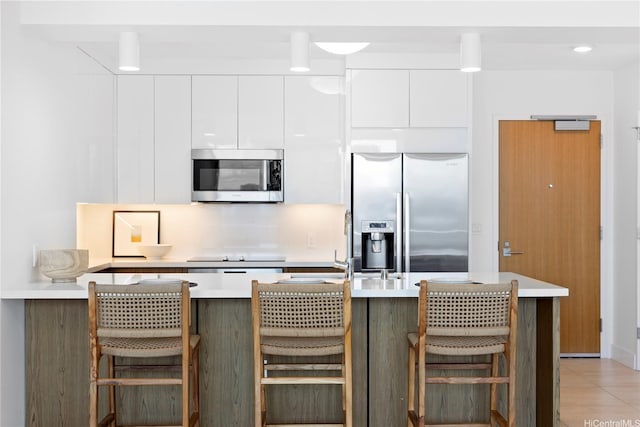 629 Keeaumoku St Unit 1902, Honolulu, HI 96814 - kitchen featuring stainless steel appliances, white cabinets, light countertops, a kitchen breakfast bar, and modern cabinets
