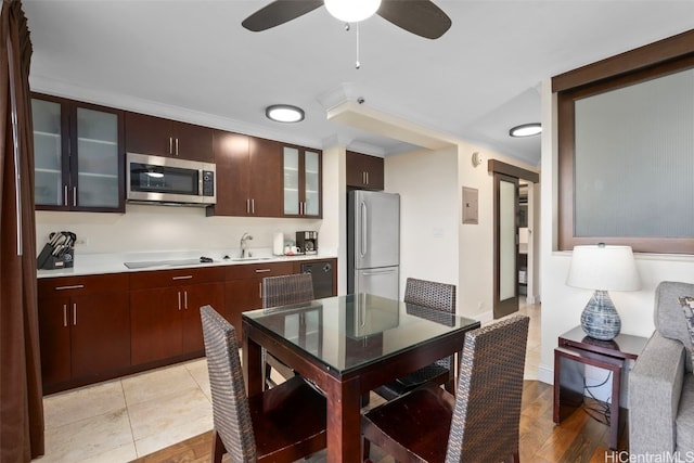 kitchen with sink, ceiling fan, light wood-type flooring, ornamental molding, and stainless steel appliances