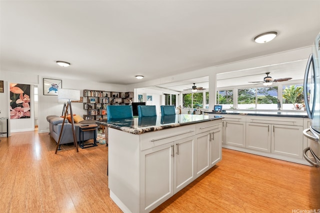 763 Kaipii St, Kailua, HI 96734 - kitchen with light wood-type flooring, a center island, white cabinets, a ceiling fan, and freestanding refrigerator