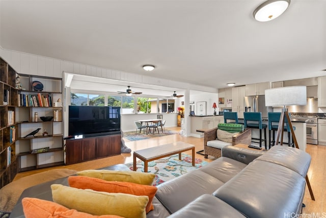 living room with ceiling fan and light hardwood / wood-style floors