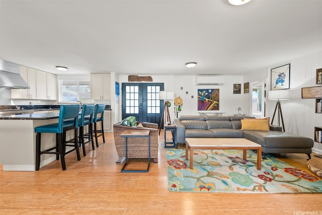 763 Kaipii St, Kailua, HI 96734 - living room with a wall mounted AC, light wood-type flooring, and french doors