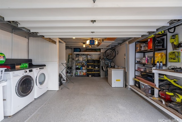 garage featuring a garage door opener, a workshop area, washing machine and clothes dryer, and refrigerator