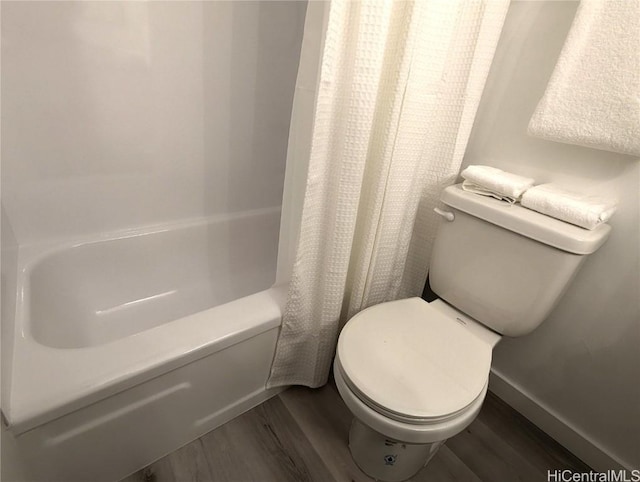 bathroom featuring shower / tub combo, hardwood / wood-style floors, and toilet