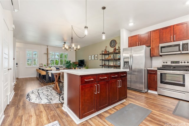 kitchen featuring a center island, hanging light fixtures, light wood-type flooring, and appliances with stainless steel finishes