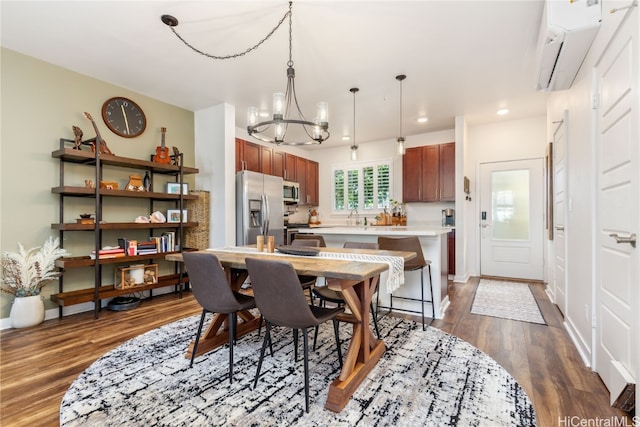 dining area with an AC wall unit, a chandelier, and dark hardwood / wood-style floors