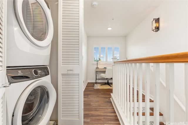 washroom with dark wood-type flooring and stacked washer / drying machine