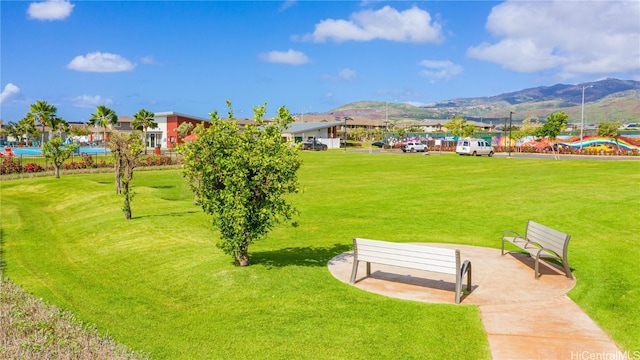 view of home's community with a mountain view and a lawn