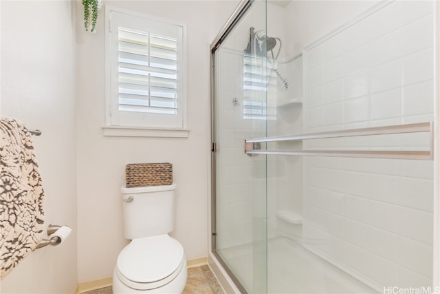 bathroom featuring tile patterned flooring, toilet, and walk in shower