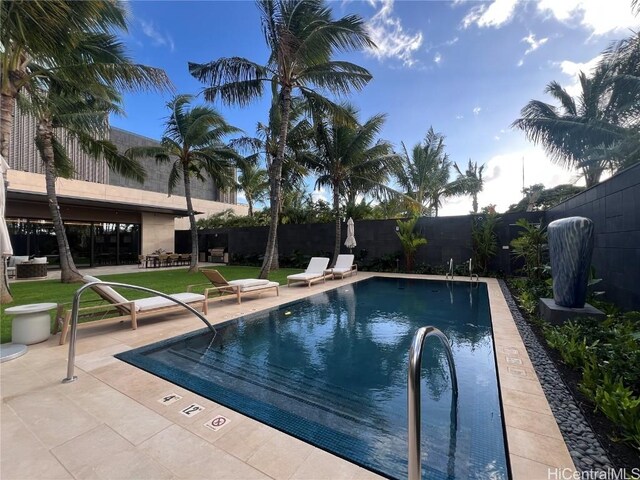 view of pool with a patio area and a yard