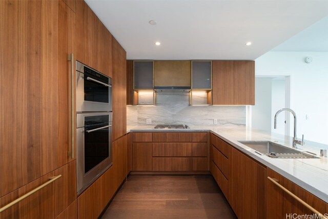 kitchen with sink, stainless steel appliances, tasteful backsplash, dark hardwood / wood-style flooring, and kitchen peninsula