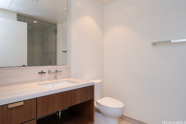 bathroom with backsplash, vanity, hardwood / wood-style flooring, toilet, and a shower with shower door