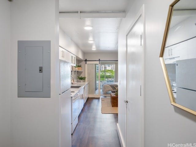 kitchen with electric panel, sink, dark hardwood / wood-style floors, a barn door, and white range oven