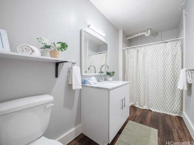 bathroom with toilet, vanity, and hardwood / wood-style flooring