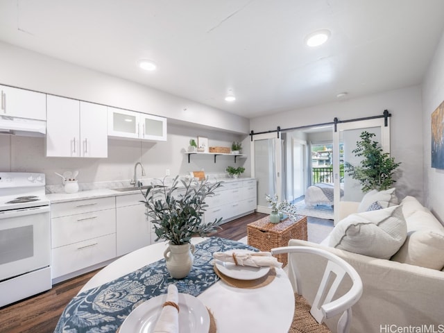 kitchen featuring sink, white electric range, a barn door, dark hardwood / wood-style flooring, and white cabinets