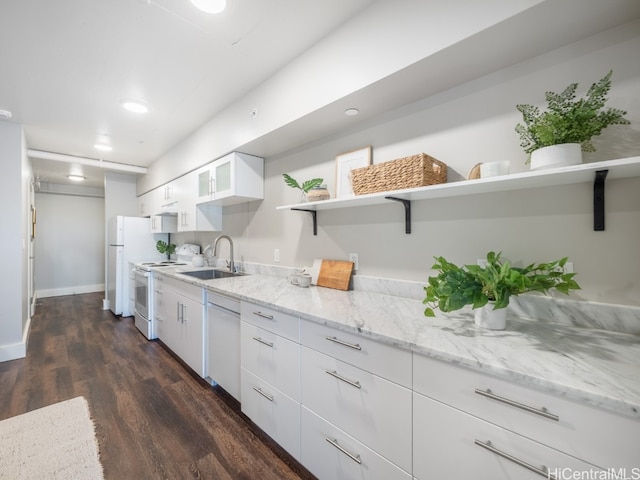 kitchen with dark hardwood / wood-style flooring, light stone counters, white appliances, sink, and white cabinetry