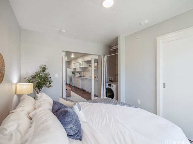 bedroom featuring white refrigerator, hardwood / wood-style flooring, washer / clothes dryer, and sink