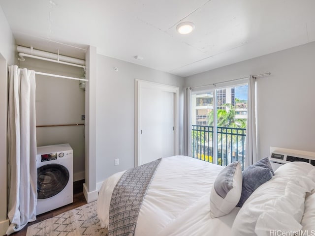 bedroom with hardwood / wood-style floors, access to exterior, and washer / clothes dryer