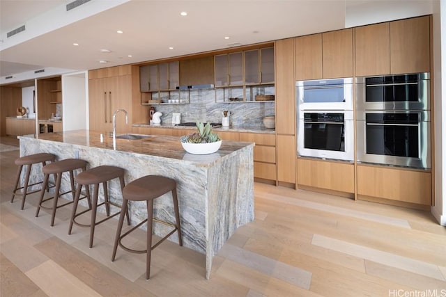 kitchen with tasteful backsplash, a large island, a kitchen bar, and appliances with stainless steel finishes