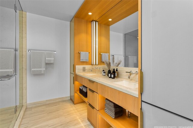 bathroom with backsplash, hardwood / wood-style floors, vanity, and walk in shower