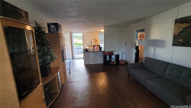 living room with a textured ceiling and dark wood-type flooring