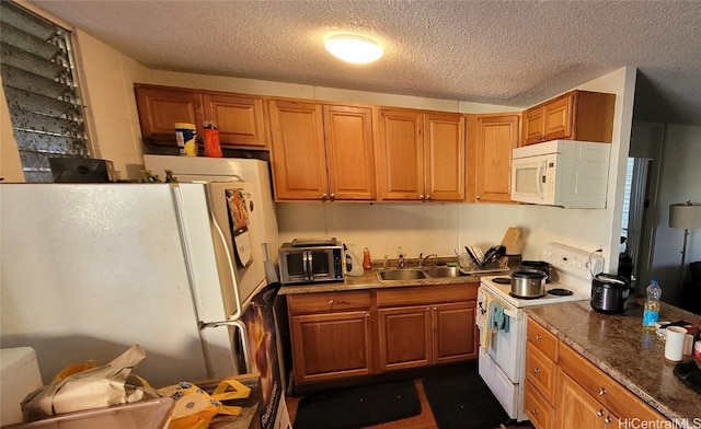 kitchen featuring sink, white appliances, and a textured ceiling