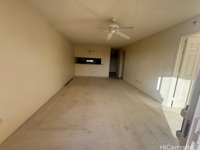 unfurnished living room featuring a textured ceiling, ceiling fan, and light carpet