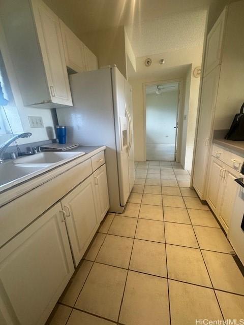 3054 Ala Poha Pl Unit 1906, Honolulu, HI 96818 - kitchen with a sink, white cabinets, light tile patterned floors, and light countertops